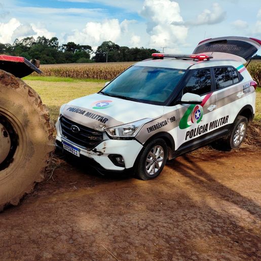 Homem em surto tenta subir com trator em cima de viatura da PM