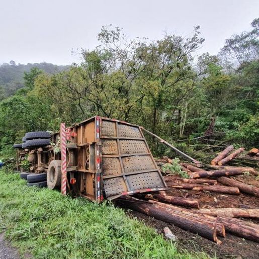 Mulher morre após caminhão carregado de madeira tombar