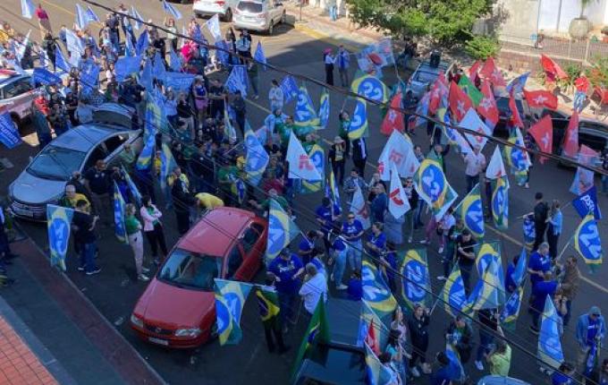 Debate de candidatos a prefeito reúne eleitores com bandeiras e carro de som em frente à Rede Peperi