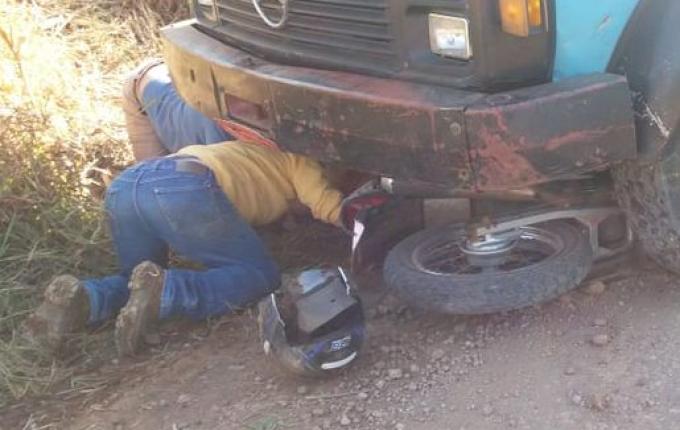 Colisão deixa motociclista preso em baixo de caminhão no interior