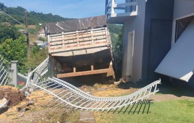 Condutor perde controle e caminhão invade pátio de residência